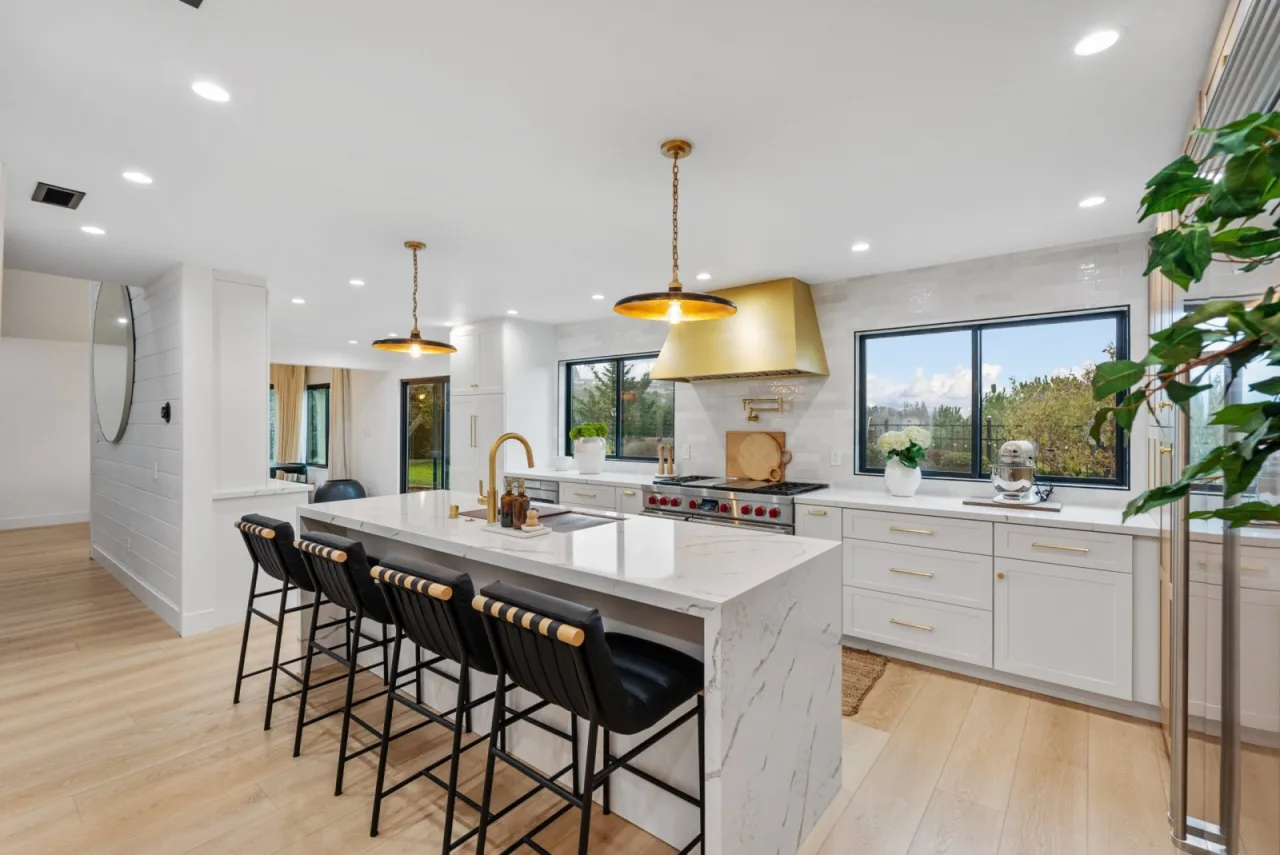 Kitchen remodel in Orinda CA with brass range hood and waterfall island by Bay Home Remodeling