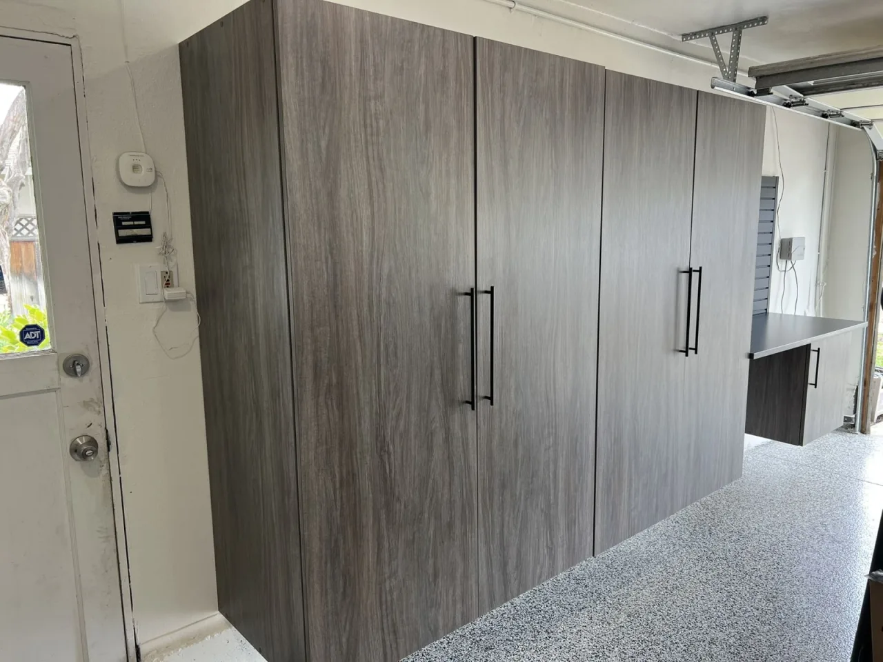 Woodgrain garage cabinets over epoxy garage floor coating in Concord CA
